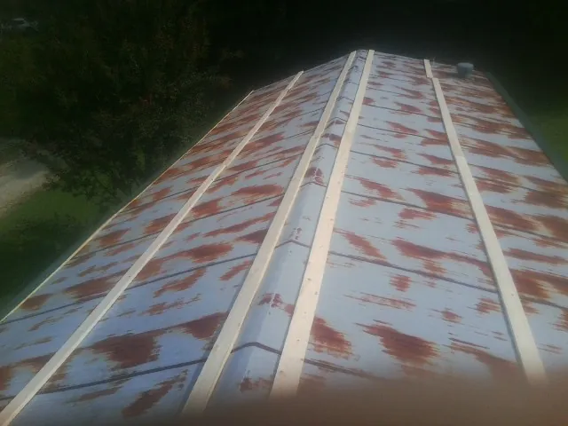 Rusted metal roof panels with new wood purlins before replacement — Storm Damage Roof Repair in Bondsville by Roofing Brothers