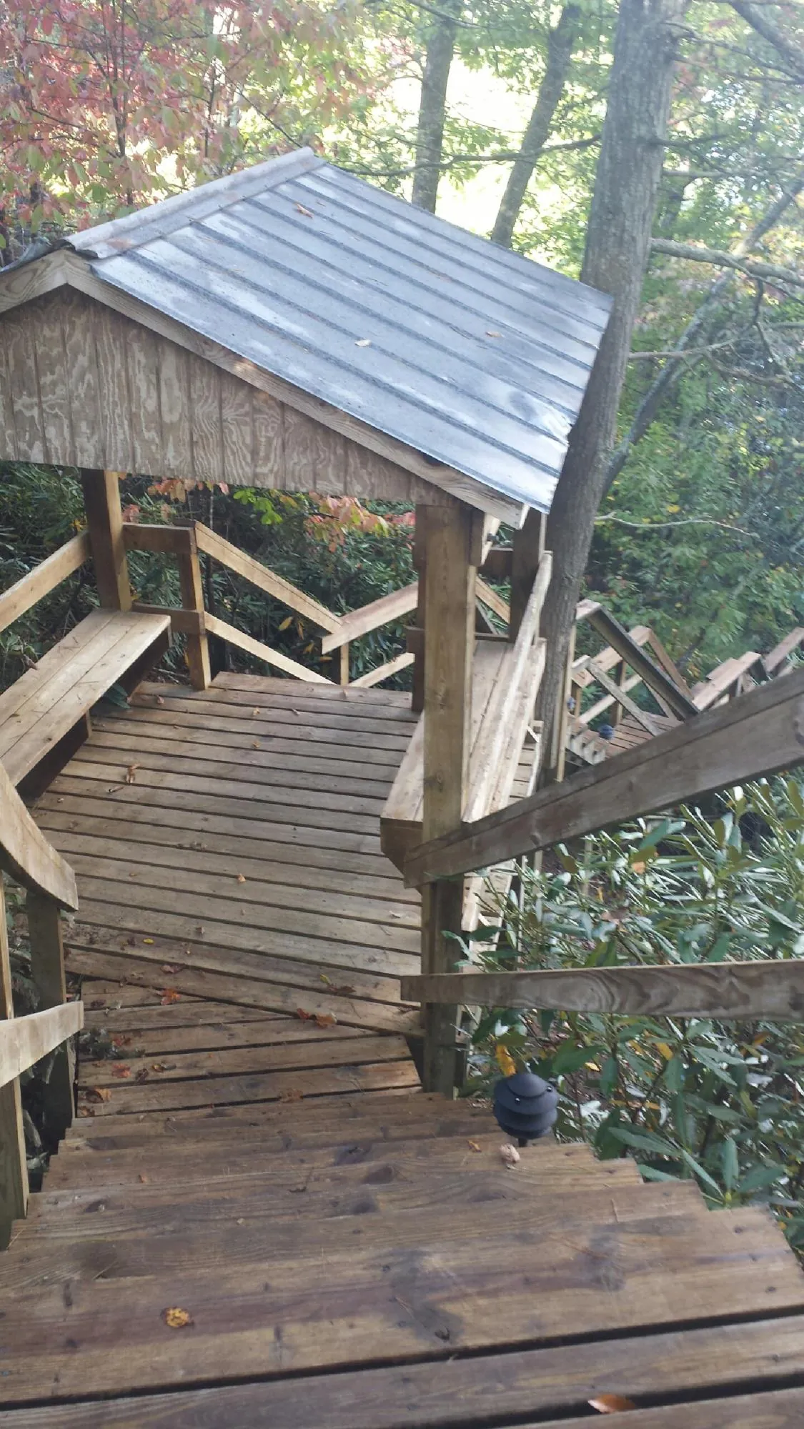 Metal roofed shelter over wooden steps on a wooded walkway — Skylight Repair & Installation work by our crew in Bondsville