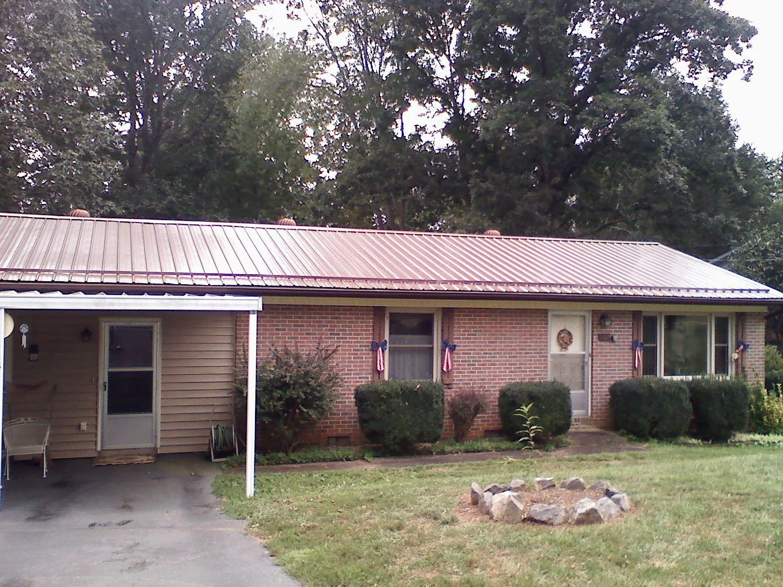 Bronze metal roof and carport on a brick ranch home — Roof Repair work by our crew in Bondsville
